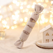 Bague dorée Amour - Bijou photographié sur coussin beige clair dans une ambiance de Noël