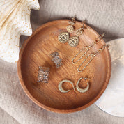 Bague dorée TOSCA - Bijou photographié dans une coupole en bois posée sur un tissu en lin beige dans une ambiance de Noël