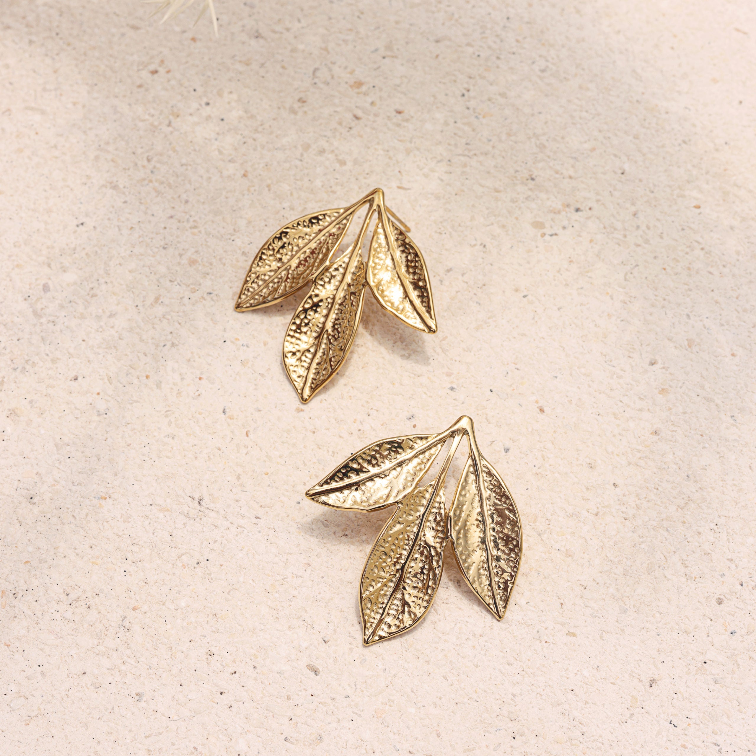 Boucles dorées Rai  - Bijou photographié sur pierre beige
