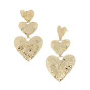 Boucles d’oreilles pendantes dorées composées de trois cœurs qui se suivent - Bijou photographié sur fond blanc 