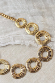 Collier doré Isaya - Bijou photographié sur tissu blanc
