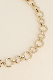 Collier doré maille Stacy - Bijou photographié sur fond beige