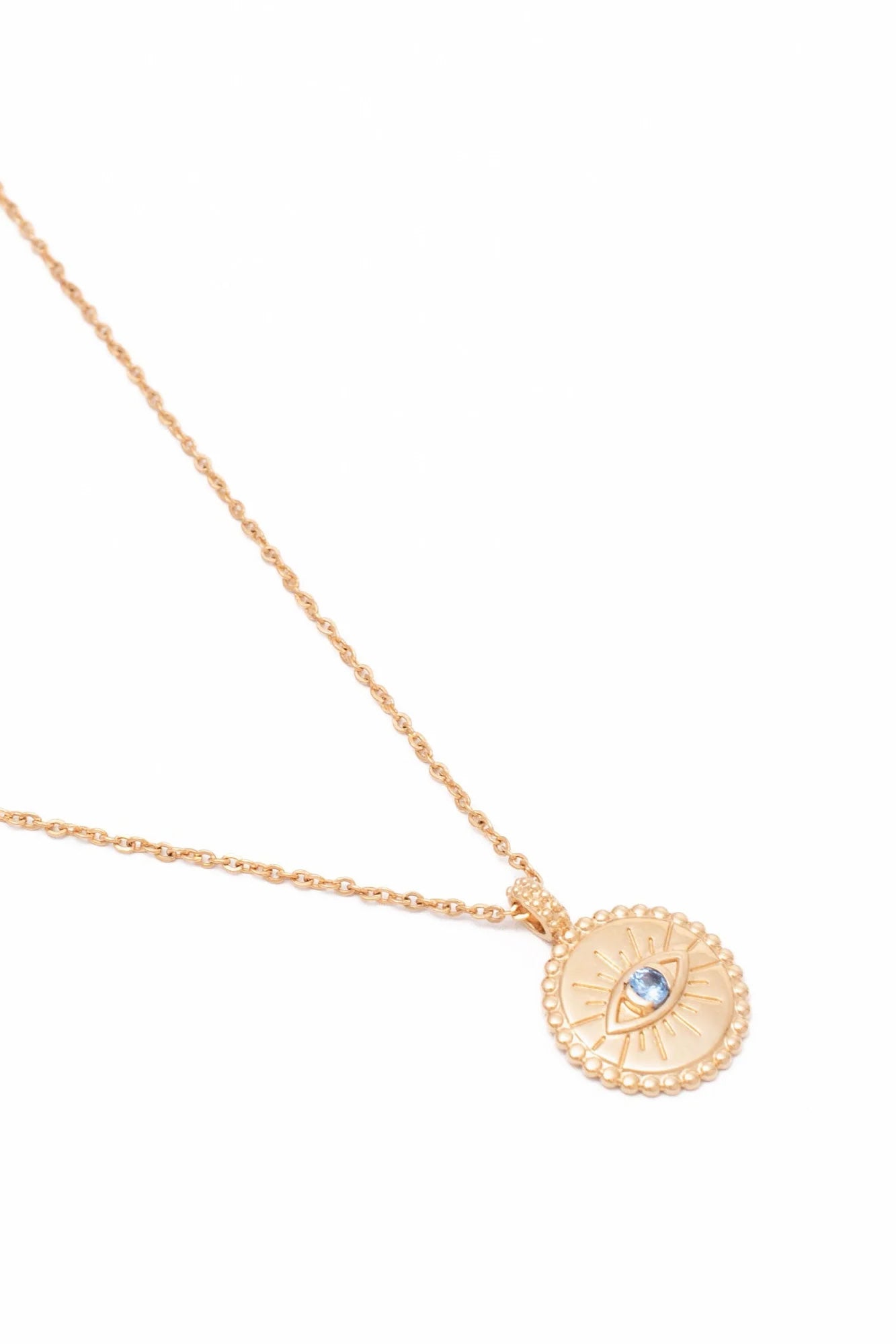 Collier doré médaille ronde œil zircon bleu - Bijou photographié sur fond blanc