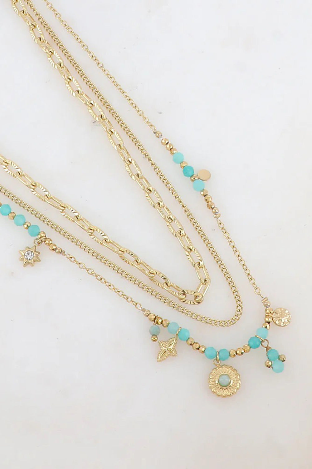 Collier triple doré Nino amazonite - Bijou photographié sur fond en marbres blanc
