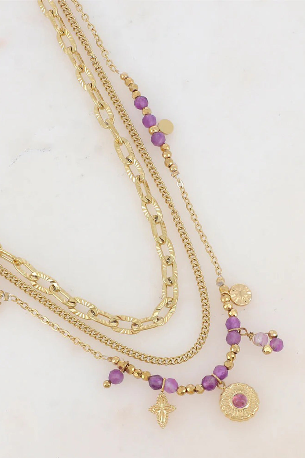 Collier triple doré Nino améthyste - Bijou photographié sur fond en marbre blanc