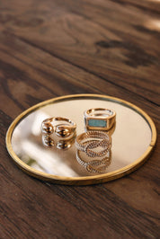 Bague dorée Delfina pierre rectangulaire amazonite - Bijou photographié sur miroir posé sur une table en bois