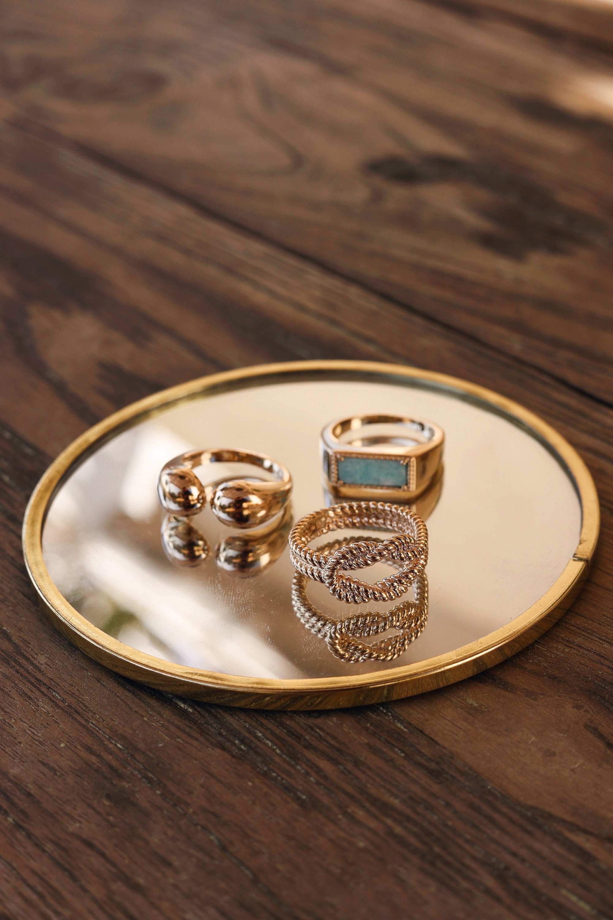 Bague dorée Delfina pierre rectangulaire amazonite - Bijou photographié sur miroir posé sur une table en bois