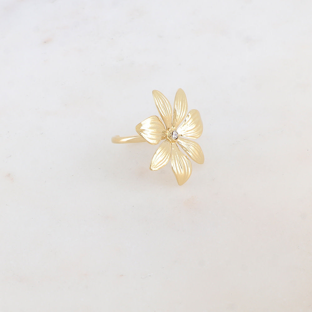  Bague dorée Gede fleur avec zircon central - Bijou photographié sur fond beige