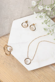 Boucles dorées Dayana cercle avec zircons - Bijou photographié sur marbre avec fleurs blanches
