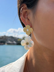 Boucles d'oreilles pendantes dorées Melanie avec fleur texturée et fleur en nacre - Bijou porté