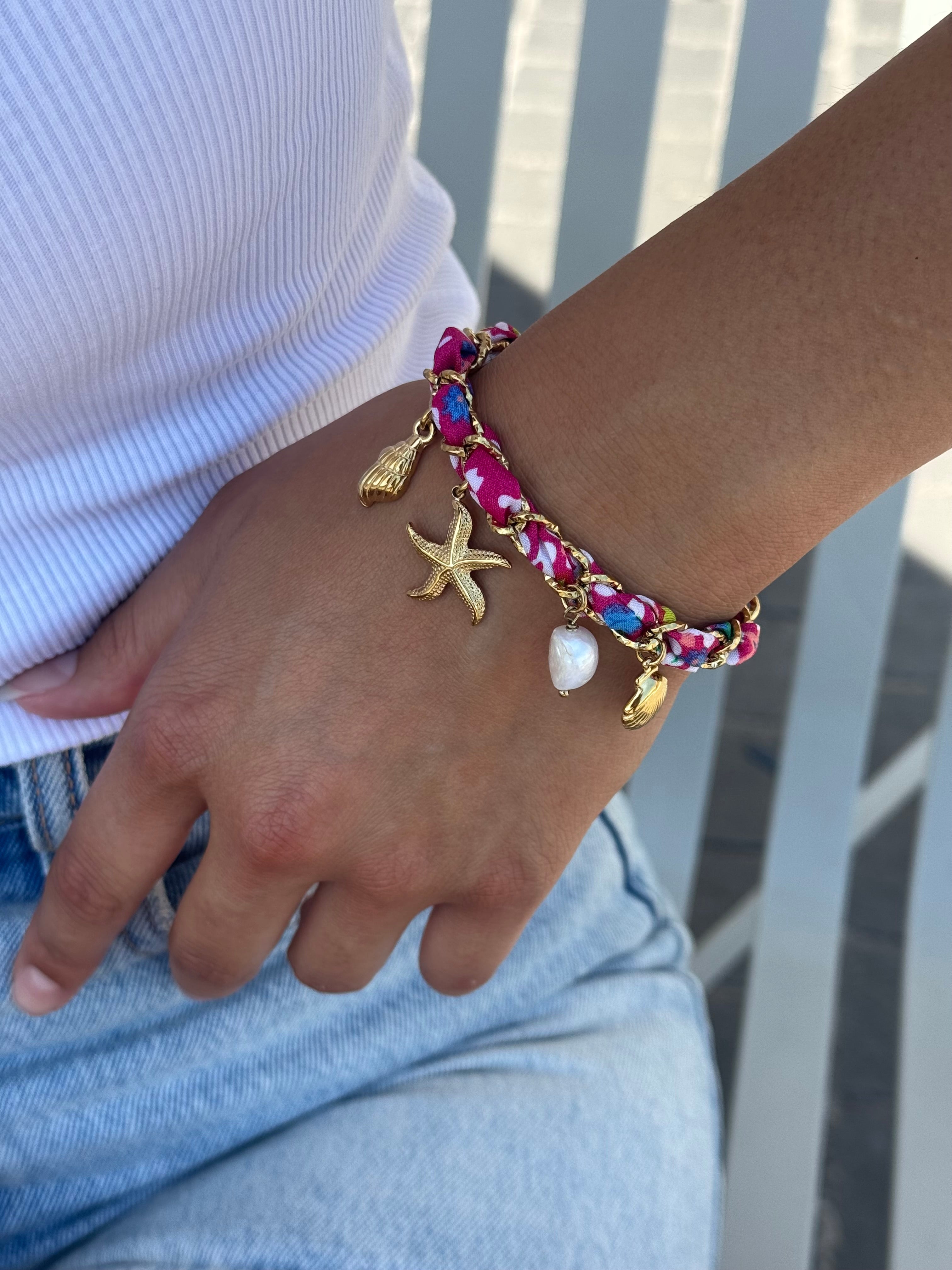 Bracelet doré Aminata fuchsia maille entrelacée avec tissu rose fuchsia pendentifs coquillages, étoile de mer et nacres - Bijou porté