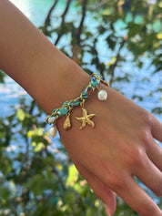 Bracelet doré Aminata maille entrelacée avec tissu turquoise pendentifs coquillages, étoile de mer et nacres - Bijou porté