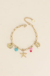 Bracelet doré Esmaa pendentifs marins et pierres naturelles - Bijou photographié sur fond beige