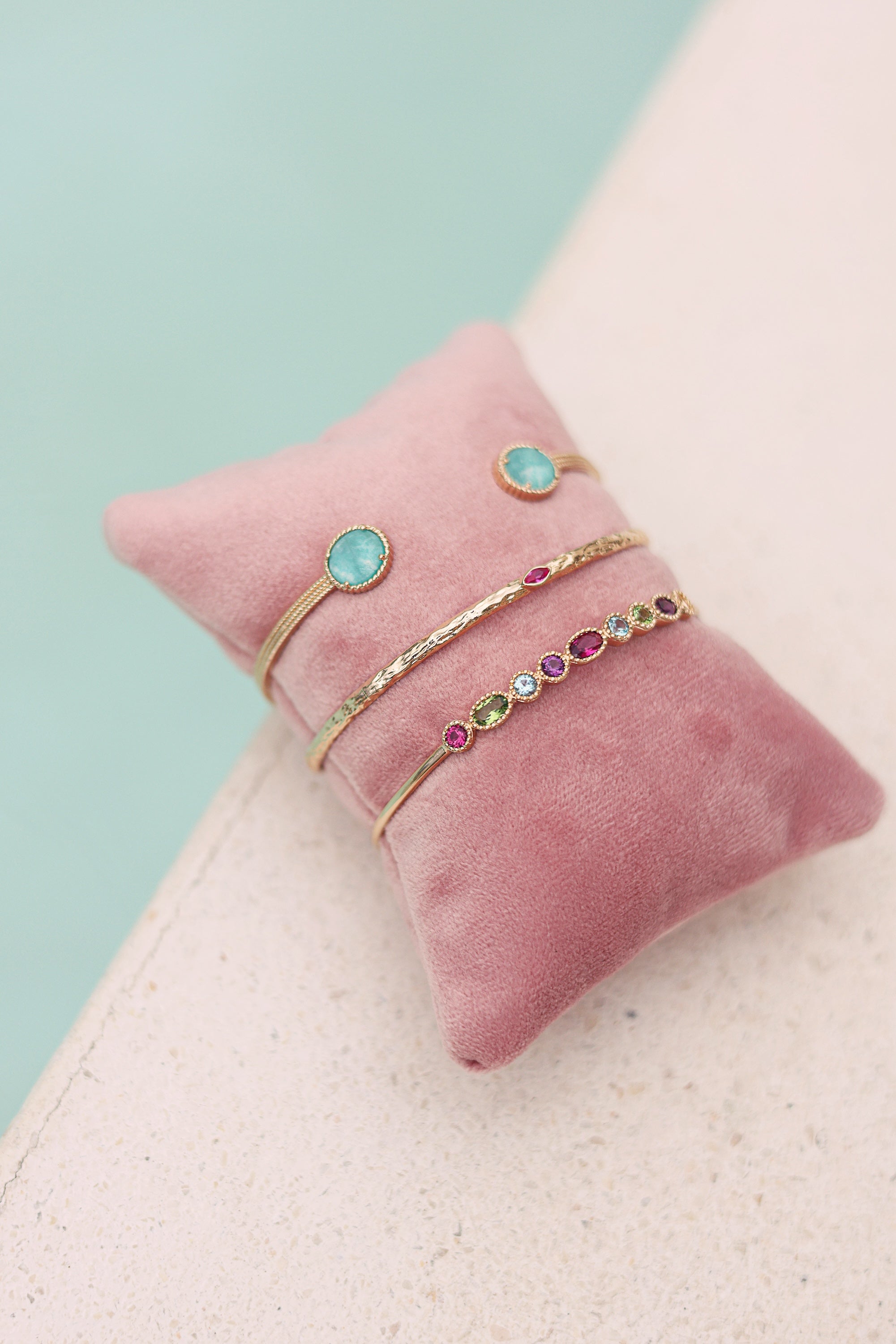 Bracelet jonc doré Miu amazonite - Bijou photographié sur coussin rose au bord d'une piscine