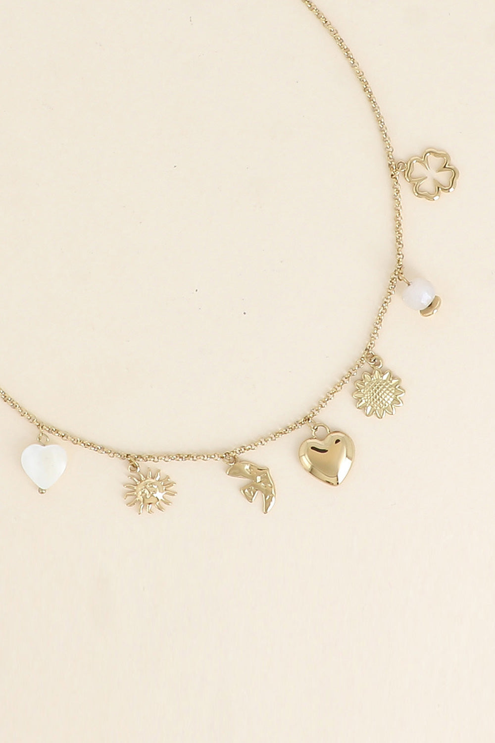 Collier doré Lorena chaîne fine avec pendentifs soleil, hirondelle, coeur, tournesol, trèfle et pierre naturelle - Bijou photographié sur fond blanc
