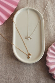 Collier personnalisable doré Ama pendentifs étoiles pour lettre ou charm - Bijou photographié dans un vide poche blanc
