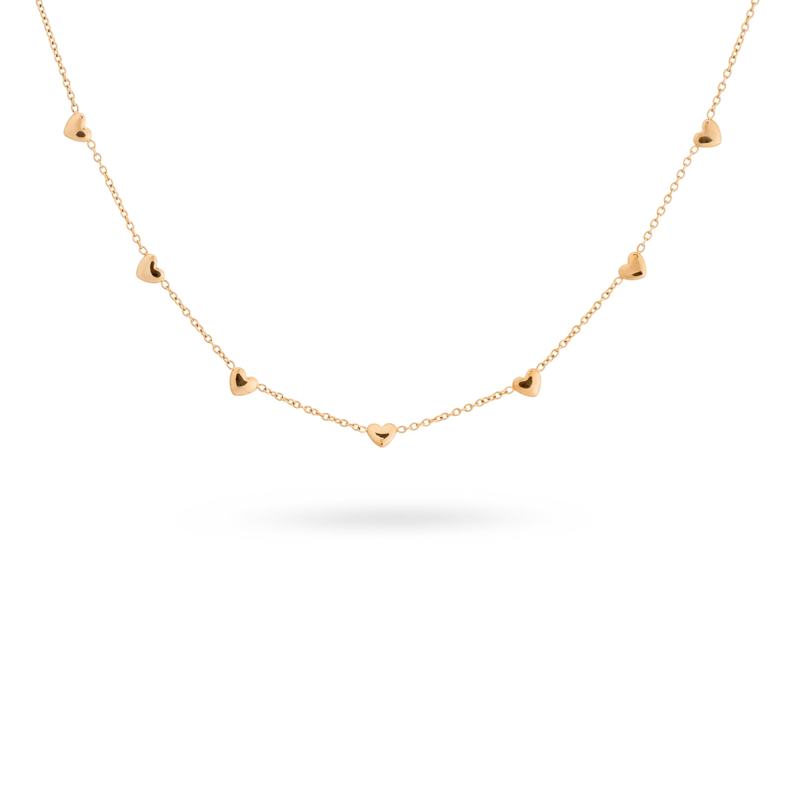 Collier doré orné de cœurs - Bijou sur fond banc