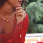 Collier maille doré Avaha avec anneau et pendentif nacre - Bijou porté dans une main