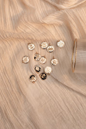 Collier doré signe du zodiaque Verseau - Bijou photographié sur tissu blanc crème